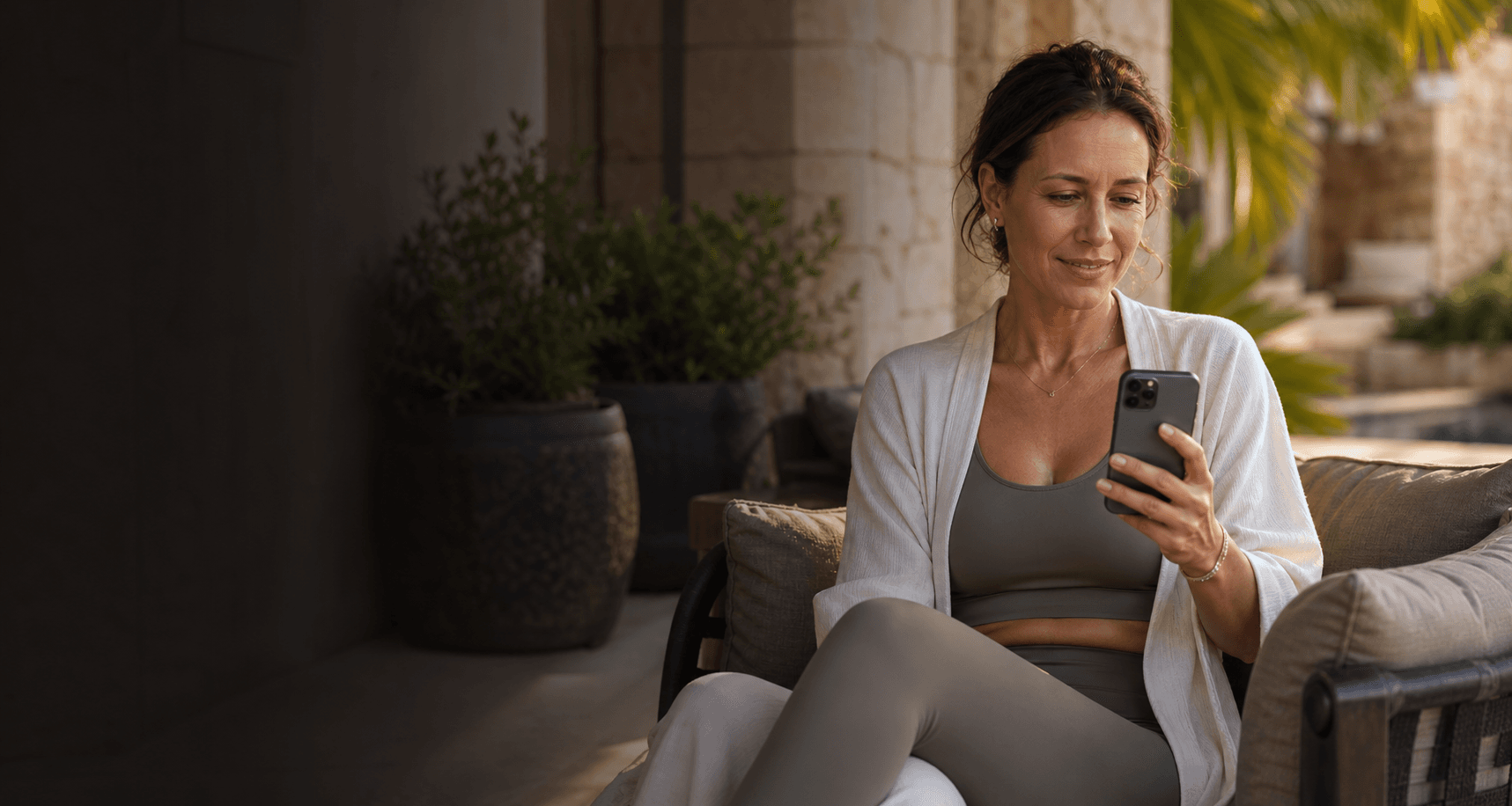 Woman using her phone at a luxury outdoor resort