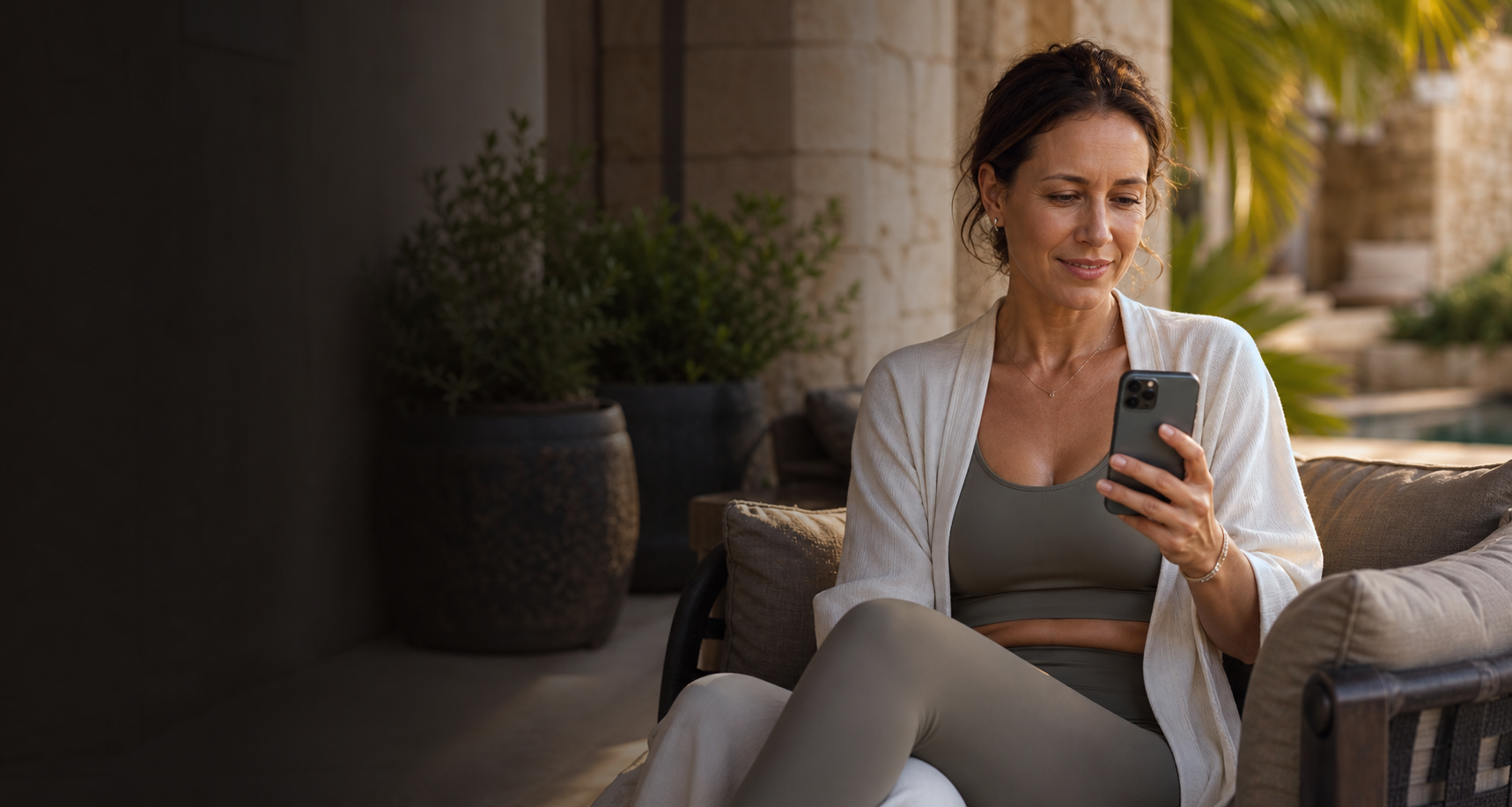 Woman using her phone at a luxury outdoor resort